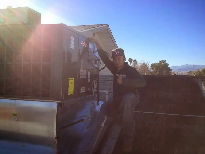 HVAC technician performing Air Duct Cleaning on a rooftop unit in Mountainside